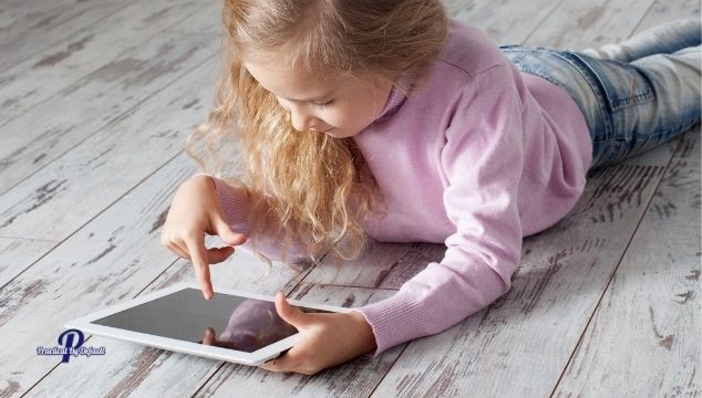 Girl using a tablet laying on the floor focus image for homeschooling apps list

