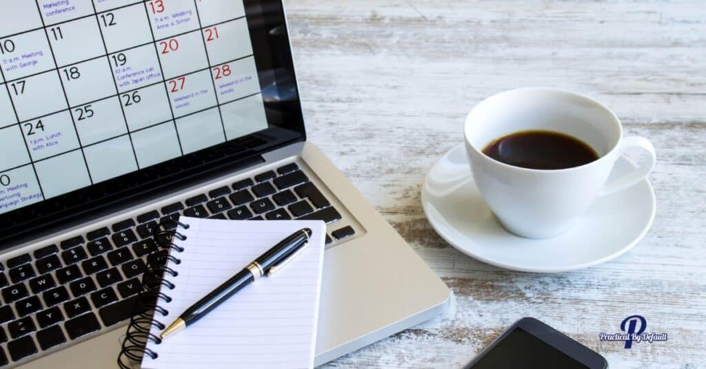 computer with a schedule, notebook and cup of coffee